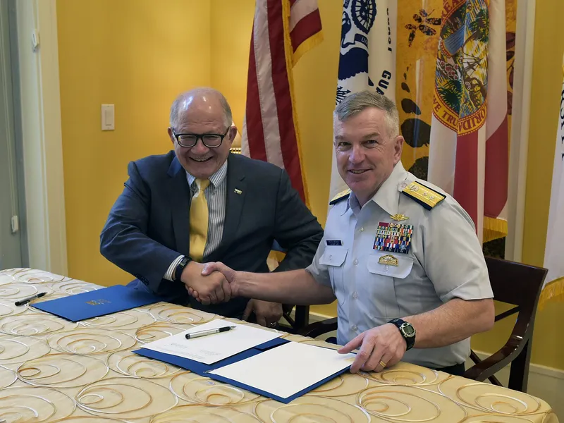 Two men shaking hands after signing an agreement